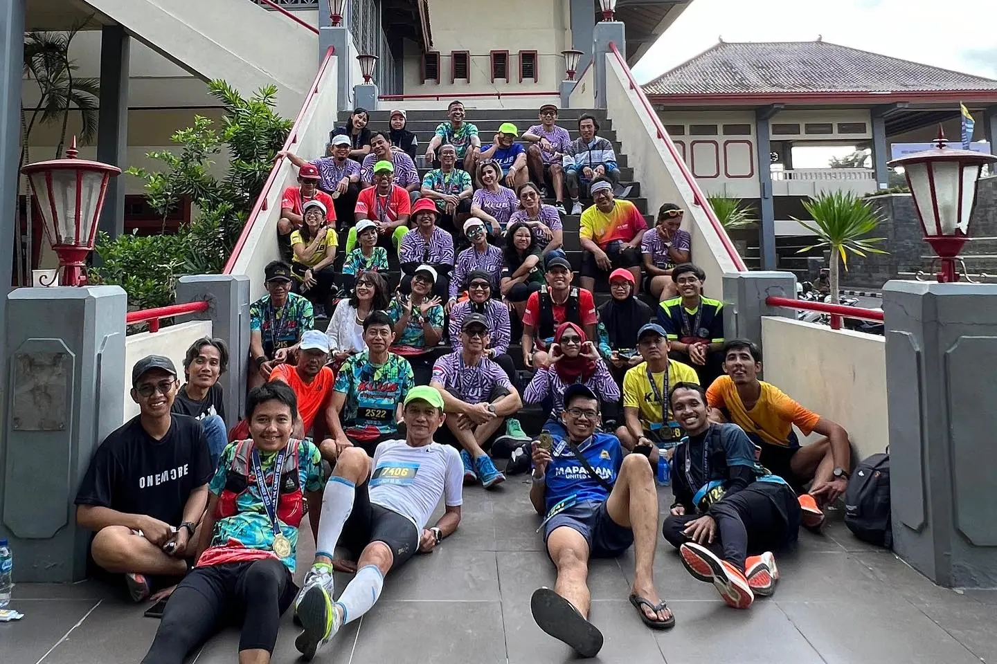 Para pelari berfoto bersama di tangga setelah finish